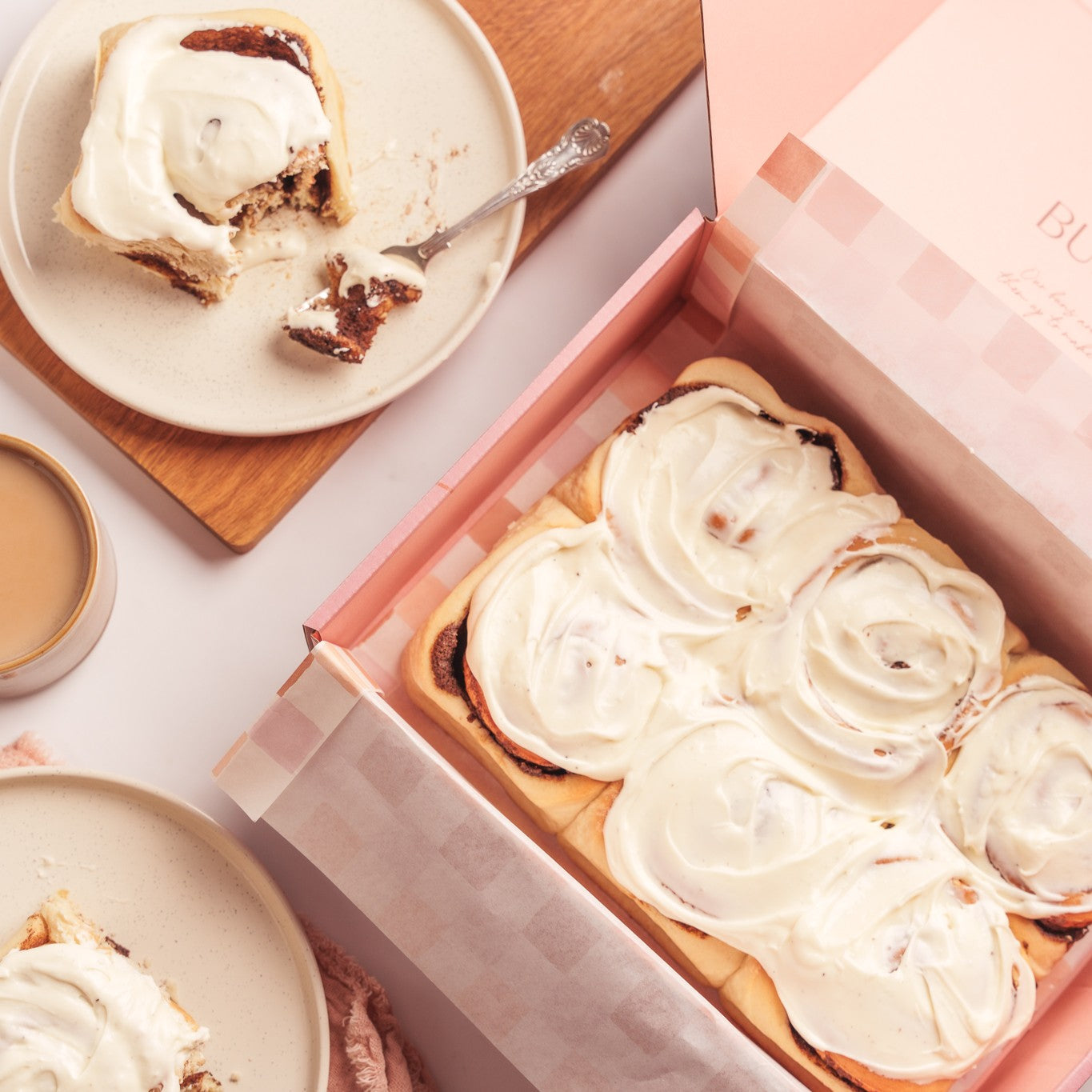 a box of cinnamon buns next to one cinnamon but cut open